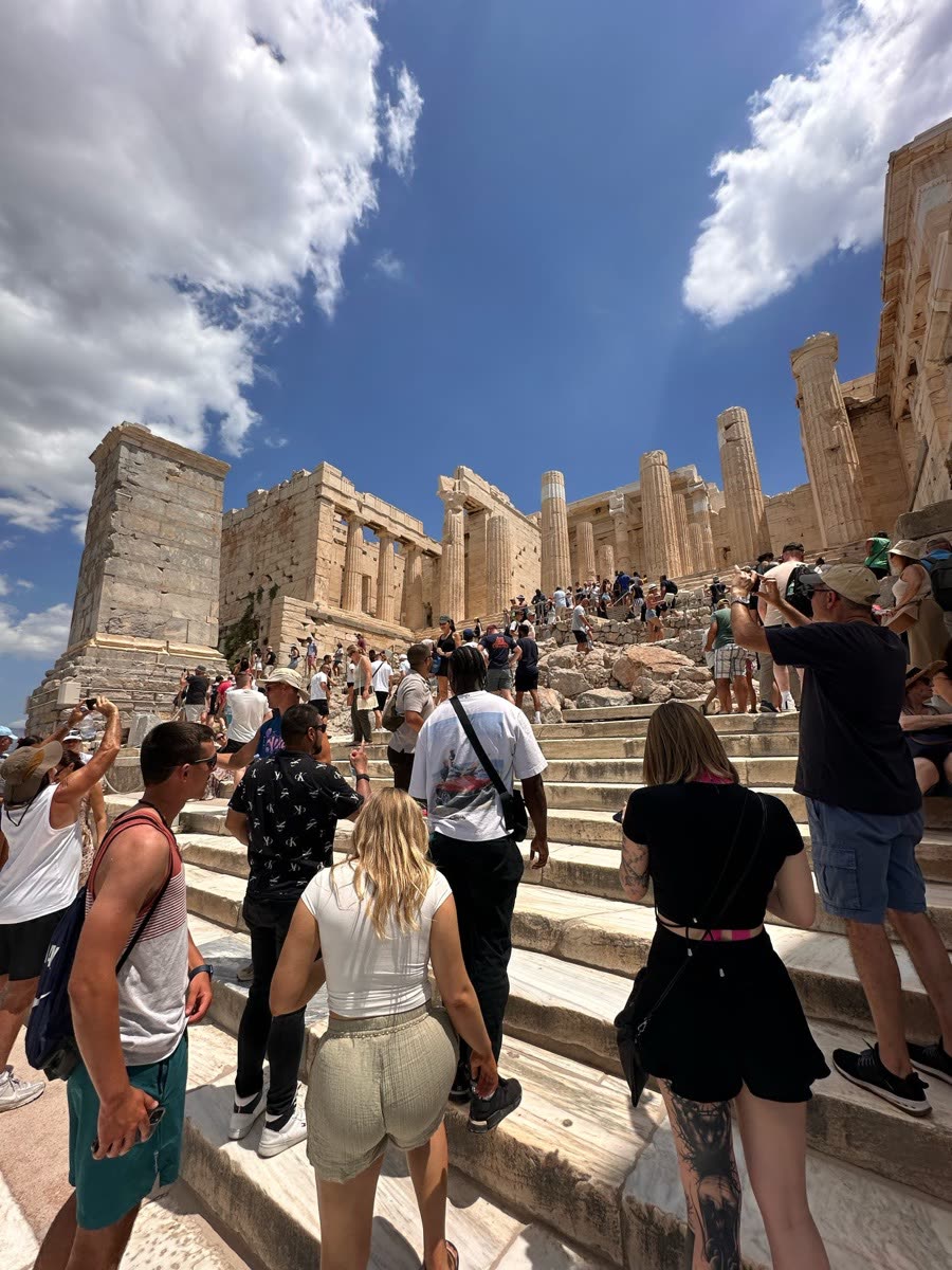 The group walking up the stone steps of an ancient site under a bright sky