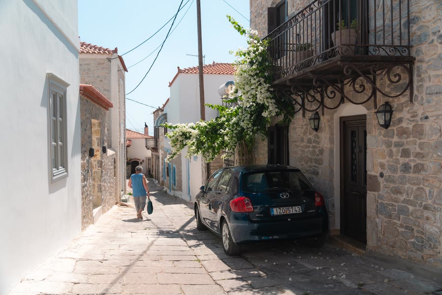 A back street of the Old Town, white walls, bougainvillea and a parked car