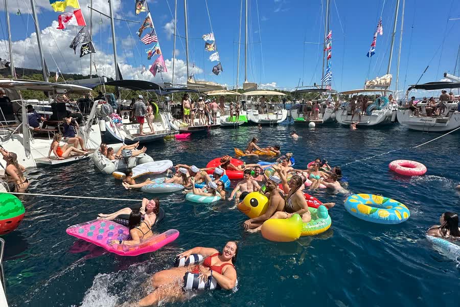 Swimmers and inflatables in the water between the rafted boats