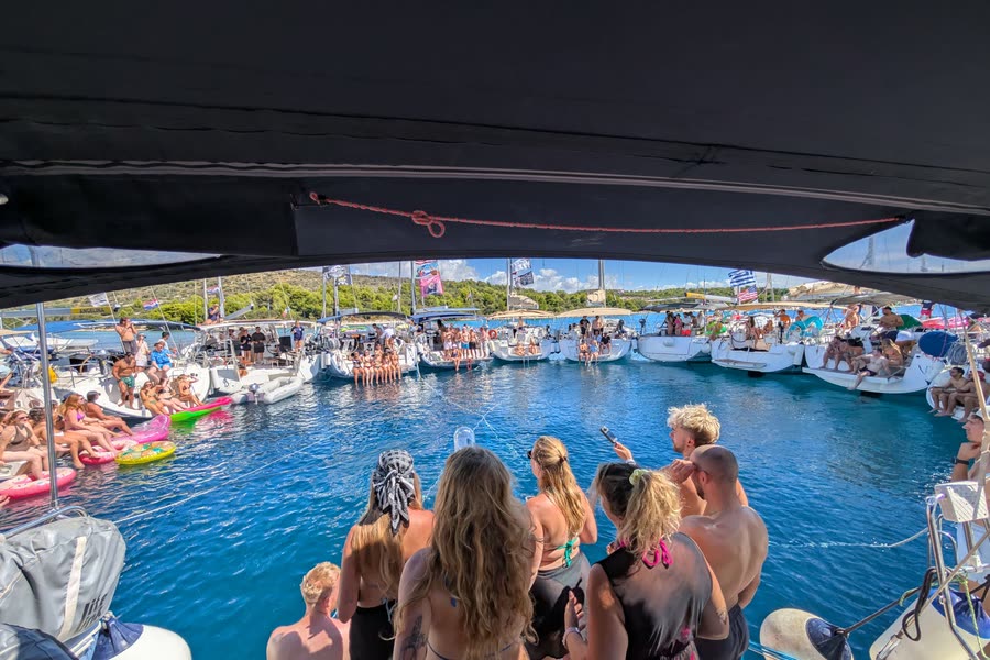 The circle of boats seen from under the boom, people watching from the deck