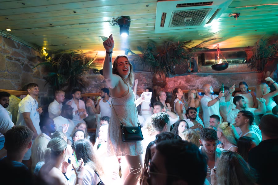 A packed club interior, everyone in white