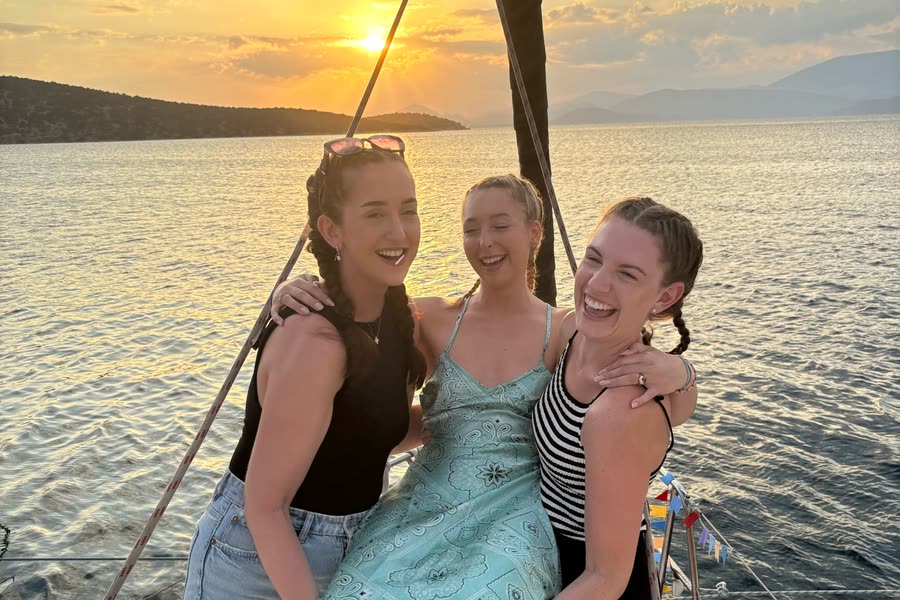 Three women on the bow at sunset